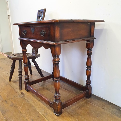 562 - A walnut sideboard, 180 cm wide, and a walnut side table, 73 cm wide, and a carved oak stool (3)