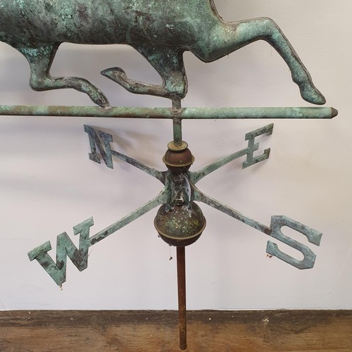 614A - A metal weather cock in the form of a horse, on a compass base, 87 cm wide