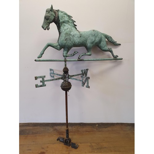 614A - A metal weather cock in the form of a horse, on a compass base, 87 cm wide