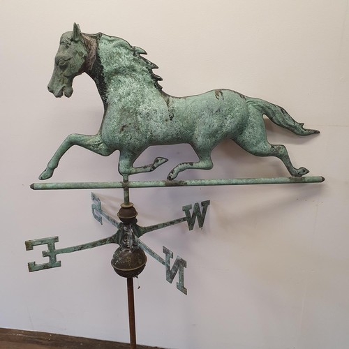 614A - A metal weather cock in the form of a horse, on a compass base, 87 cm wide