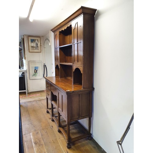 549 - An oak dresser, the top having two cupboard doors and two shelves, the base with three drawers and a... 