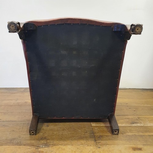 537 - A George III style wing armchair, upholstered in leather, on cabriole front legs, with claw and ball... 