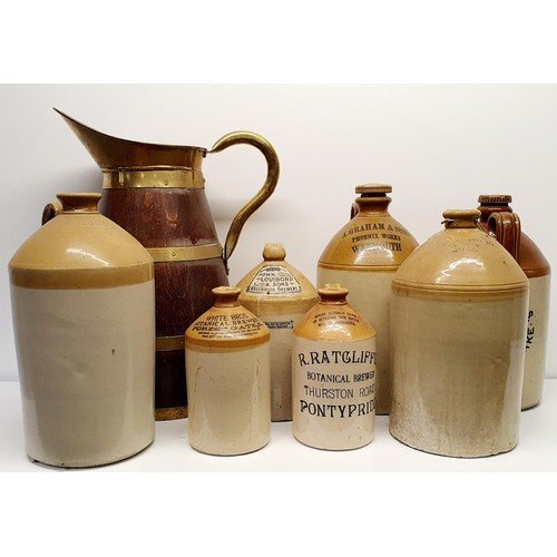 365 - An oak and brass bound jug, 60 cm high, and assorted stoneware bottles (8)