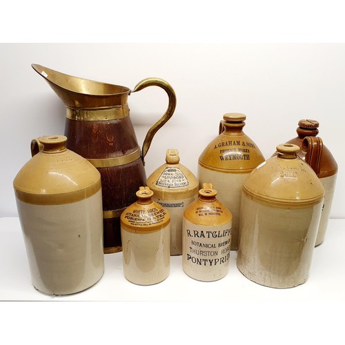 365 - An oak and brass bound jug, 60 cm high, and assorted stoneware bottles (8)