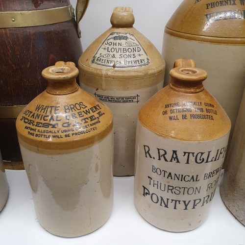 365 - An oak and brass bound jug, 60 cm high, and assorted stoneware bottles (8)