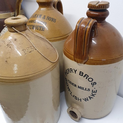 365 - An oak and brass bound jug, 60 cm high, and assorted stoneware bottles (8)