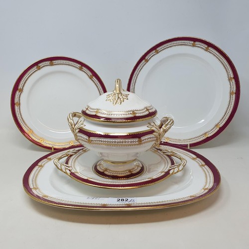 282 - An extensive late 19th/early 20th century dinner service, decorated with a dark pink border, highlig... 