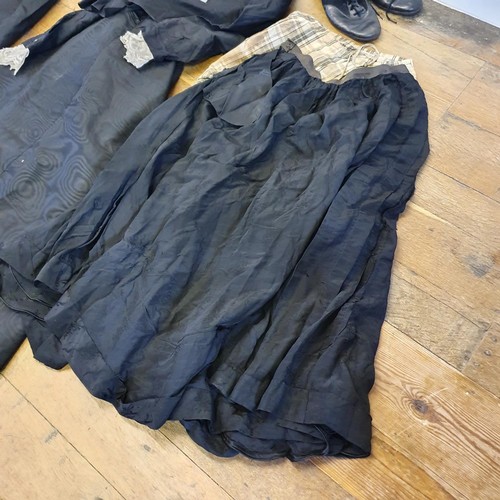 303 - An early 20th century/late 19th century black dress, other textiles and a pair of boots (box)