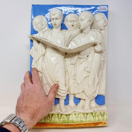 324 - A Continental pottery wall plaque, decorated choristers, 40 x 27 cm