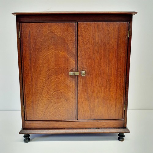 389 - An early 20th century walnut table top two door cabinet, on turned feet, 31 cm wide