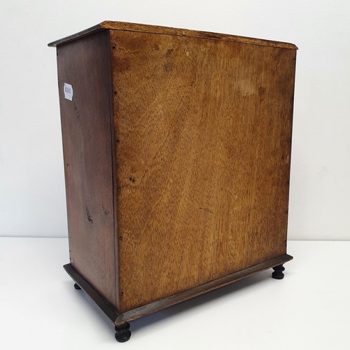 389 - An early 20th century walnut table top two door cabinet, on turned feet, 31 cm wide