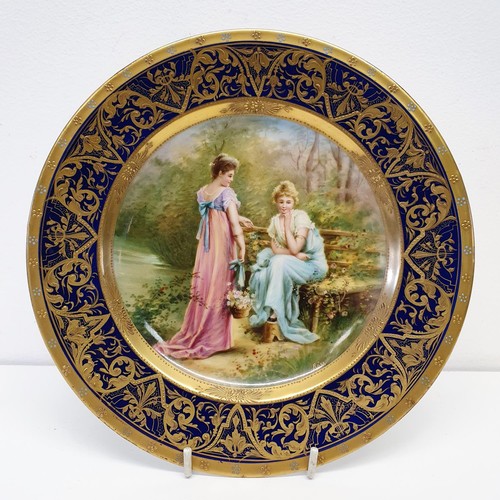 422 - A Vienna porcelain plate, Liebesgeheimnis, within a blue and gilt border, 21 cm diameter