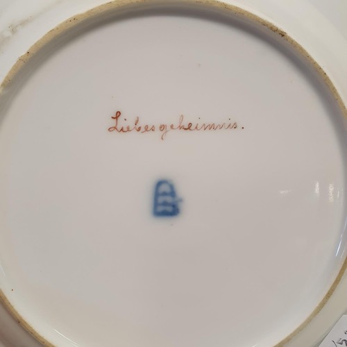 422 - A Vienna porcelain plate, Liebesgeheimnis, within a blue and gilt border, 21 cm diameter