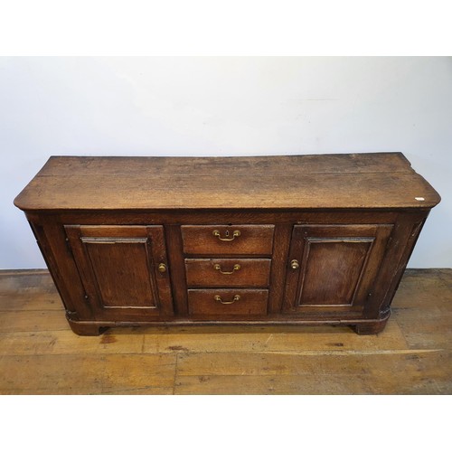 643 - An oak dresser base, having three drawers, flanked by two cupboard doors, 165 cm wide