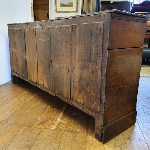 643 - An oak dresser base, having three drawers, flanked by two cupboard doors, 165 cm wide