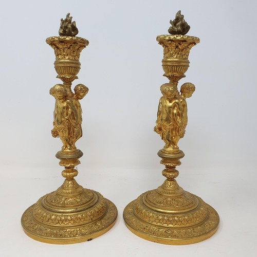 356 - A pair of gilt metal candlesticks, the stems in the form of three putti holding festoons, 28 cm high... 