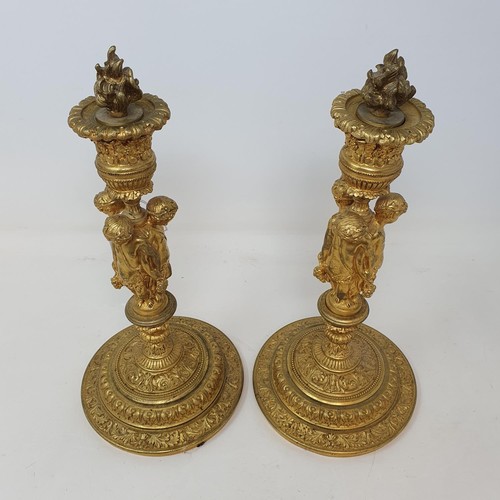 356 - A pair of gilt metal candlesticks, the stems in the form of three putti holding festoons, 28 cm high... 