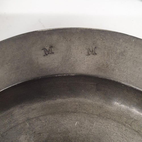 385 - An 18th century pewter plate, 39 cm diameter, and four others, 22 cm diameter (5)