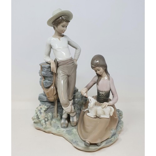 392 - A Lladro group, of a young couple feeding a lamb, 28 cm high