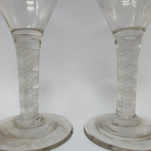 416 - A near pair of cordial glasses, with double cotton twist stems, 12.5 cm high, one with a foot rim ch... 