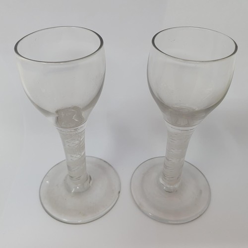 416 - A near pair of cordial glasses, with double cotton twist stems, 12.5 cm high, one with a foot rim ch... 