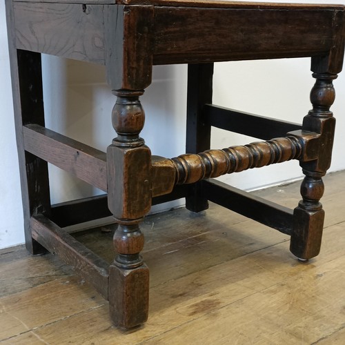 555 - A 17th century single chair, with a carved panel back and seat, on turned legs