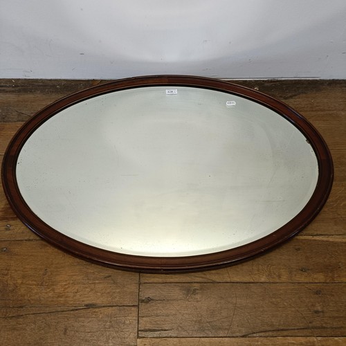 558 - A stained glass panel, 85 x 46 cm, an oval mirror, and two other mirrors (4)