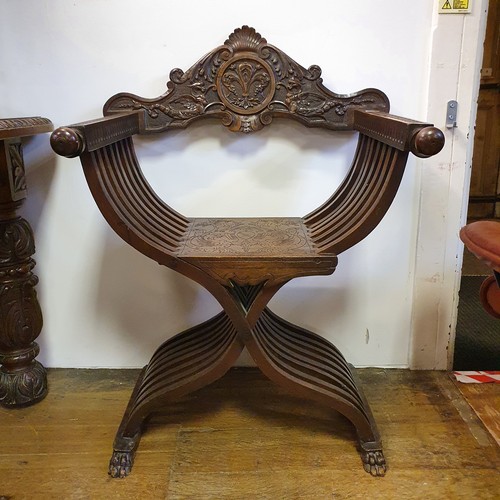 649 - An Italian carved walnut folding X frame armchair