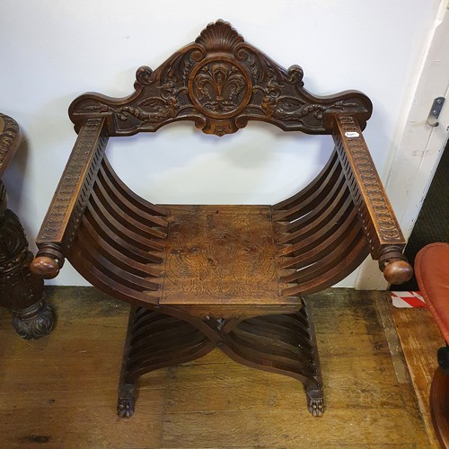 649 - An Italian carved walnut folding X frame armchair