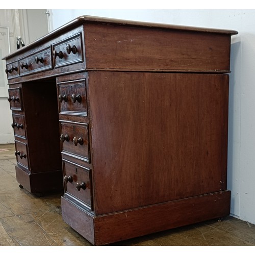 565 - A mahogany pedestal desk, having a nine drawer configuration, 120 cm wide