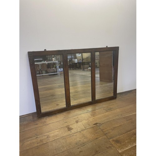 633 - A triptych mirror, in a studded leather frame, 94 x 138 cm