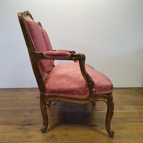 545 - An early 20th century carved wood and gilt framed double armchair, with a padded back, arms and seat... 