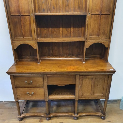 549 - An oak dresser, the top having two cupboard doors and two shelves, the base with three drawers and a... 