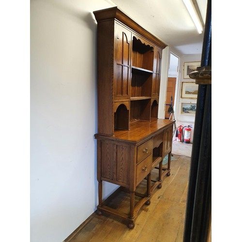 549 - An oak dresser, the top having two cupboard doors and two shelves, the base with three drawers and a... 