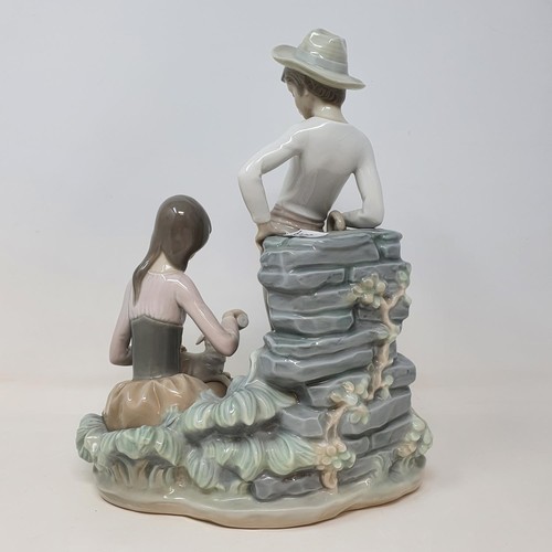 392 - A Lladro group, of a young couple feeding a lamb, 28 cm high