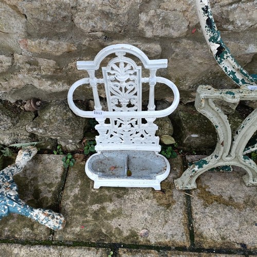 614 - A garden table, with a cast iron base and a marble top, 60 cm diameter, a pair of bench ends, and a ... 