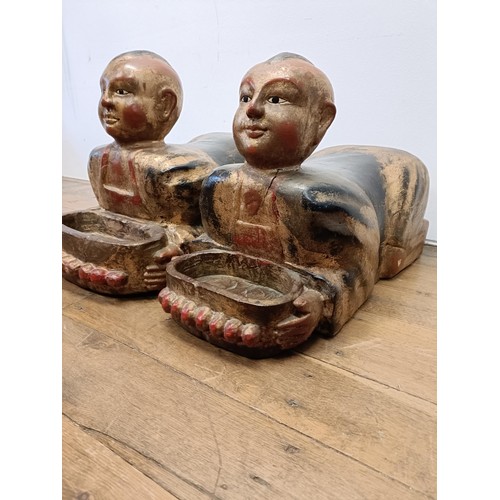 43 - A pair of Chinese carved wood figures, kneeling and holding a bowl, 70 cm wide (2)