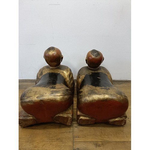 43 - A pair of Chinese carved wood figures, kneeling and holding a bowl, 70 cm wide (2)