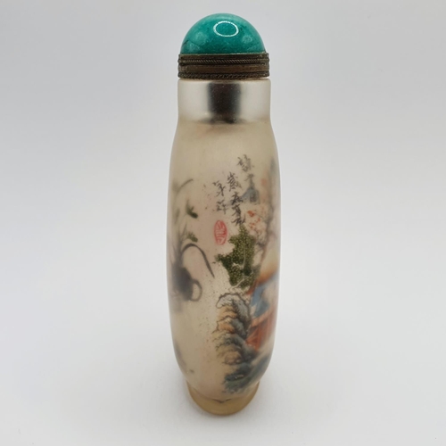 14 - A Chinese glass snuff bottle, the interior painted a landscape, with a turquoise stopper, 10 cm high... 