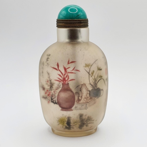 14 - A Chinese glass snuff bottle, the interior painted a landscape, with a turquoise stopper, 10 cm high... 