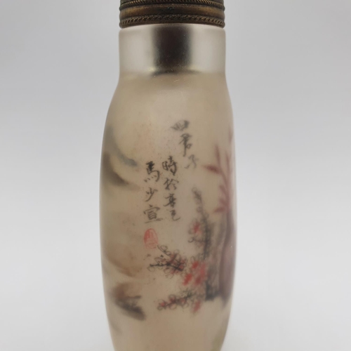 14 - A Chinese glass snuff bottle, the interior painted a landscape, with a turquoise stopper, 10 cm high... 