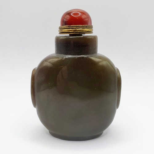 4 - A Chinese green stone snuff bottle, with an amber coloured stone stopper, 9 cm high   
Provenance: F... 