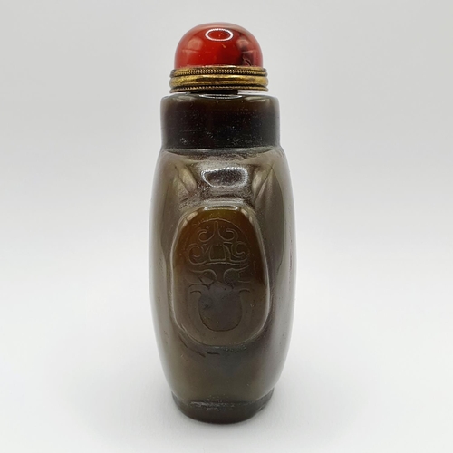 4 - A Chinese green stone snuff bottle, with an amber coloured stone stopper, 9 cm high   
Provenance: F... 