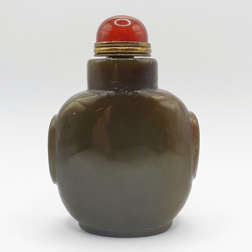 4 - A Chinese green stone snuff bottle, with an amber coloured stone stopper, 9 cm high   
Provenance: F... 