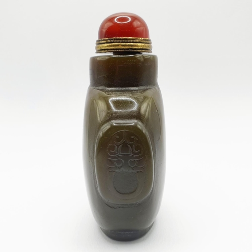 4 - A Chinese green stone snuff bottle, with an amber coloured stone stopper, 9 cm high   
Provenance: F... 