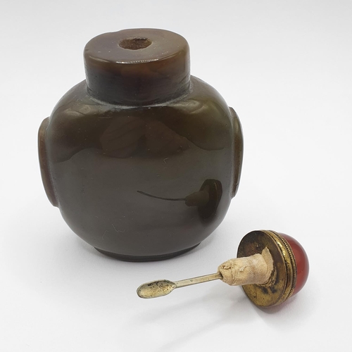 4 - A Chinese green stone snuff bottle, with an amber coloured stone stopper, 9 cm high   
Provenance: F... 