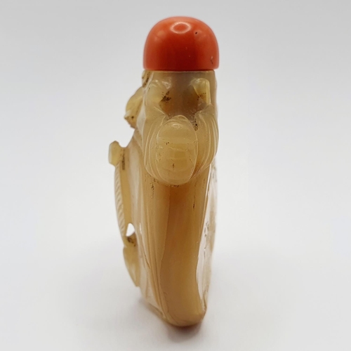 6 - A Chinese carved mother of pearl snuff bottle, with a coral stopper, 6 cm high 
Provenance: From a s... 