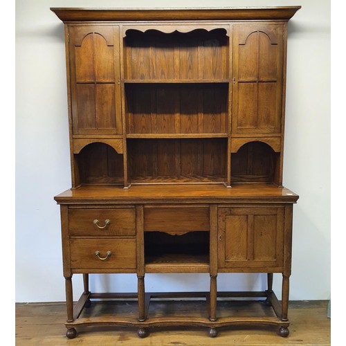 1231 - An oak dresser, the top having two cupboard doors and two shelves, the base with three drawers and a... 