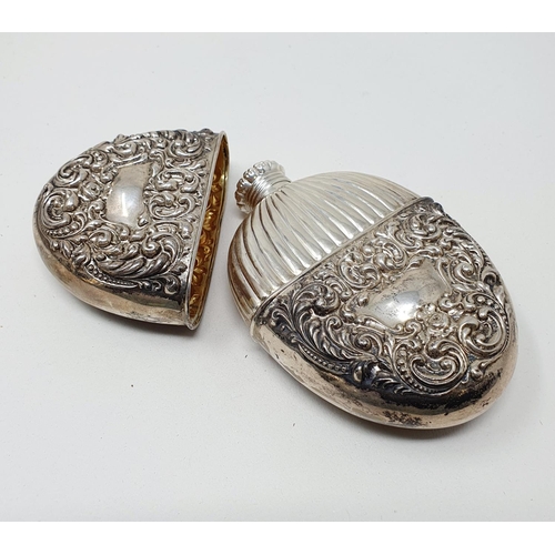 661 - A Sterling silver flask and cup, of oval form, embossed scrolling foliage, 2.6 ozt, 12 cm high