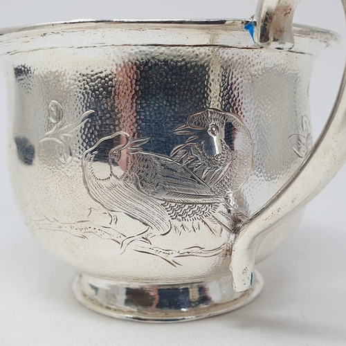 678 - A Chinese silver coloured metal cup or mug, decorated a bird and foliage, 6 cm high